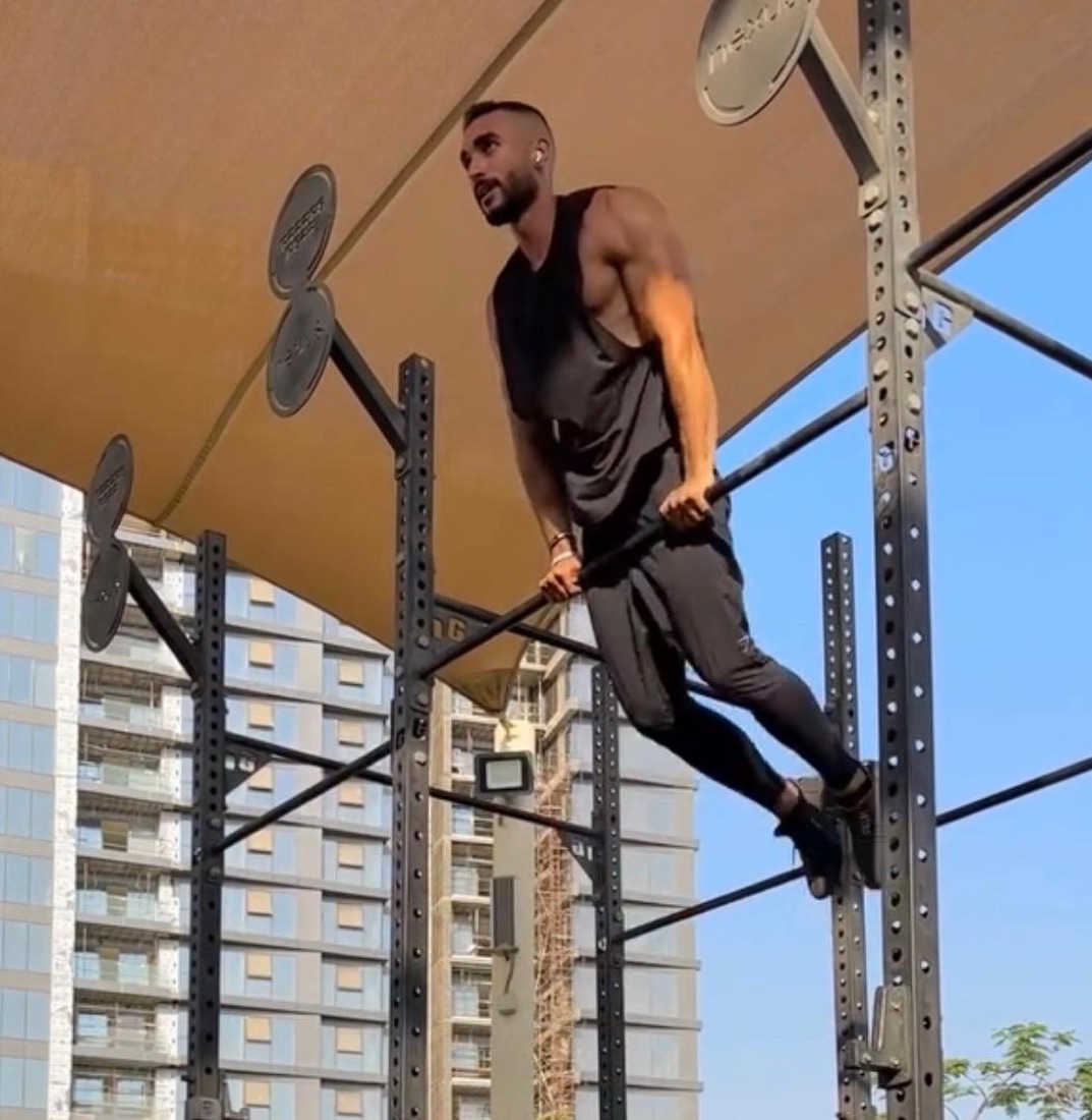Hima training outdoors on a pull-up rig